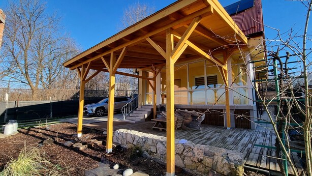 A covered outdoor area with a wooden structure, stone walls, and a vehicle parked nearby. - Cottage off the beaten track 3 rooms 2 bathrooms

 (Kraków)