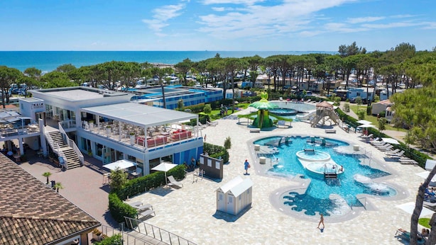 Un resort con piscina, mobiliario exterior y vistas al mar.