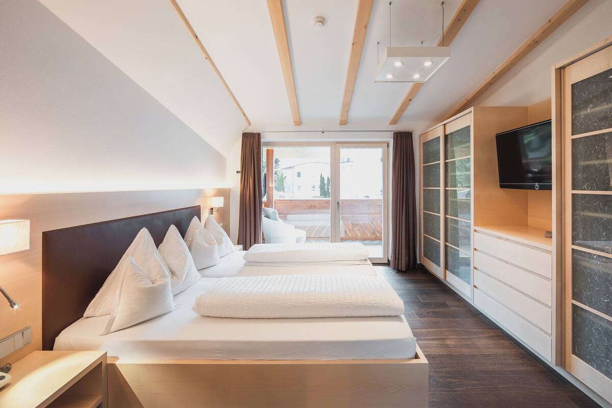 Een hotelkamer met een groot bed, een televisie, een bureau en uitzicht.