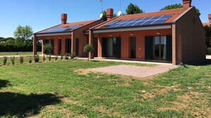 A two-story building with solar panels on the roof, brick exterior, and a paved driveway.