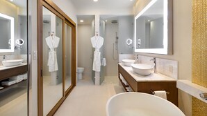 Ein modernes Badezimmer mit einem großen Spiegel, zwei Waschbecken, einer Badewanne und einer begehbaren Dusche.