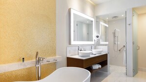Ein modernes Badezimmer mit freistehender Badewanne, zwei Waschbecken, einem großen Spiegel und einer separaten Duschkabine.