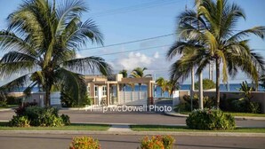 A resort with palm trees, a pool, and a view of the ocean. - Ocean Escape - pools, beach, multiple courts, gym (Lucea)