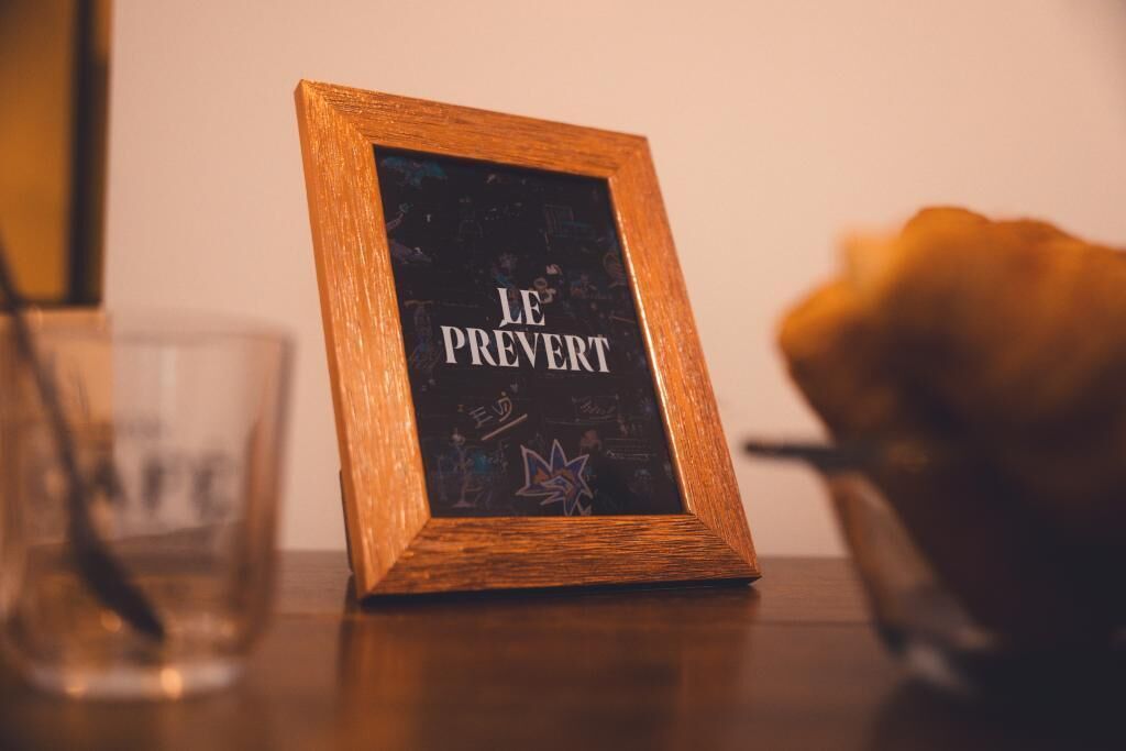 Een lijst met de tekst 'JE PREVERT' op een tafel.
