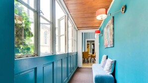 A hallway with teal walls, a wooden ceiling, and a blue bench. - Beautiful Apartment in Prague (Prague)