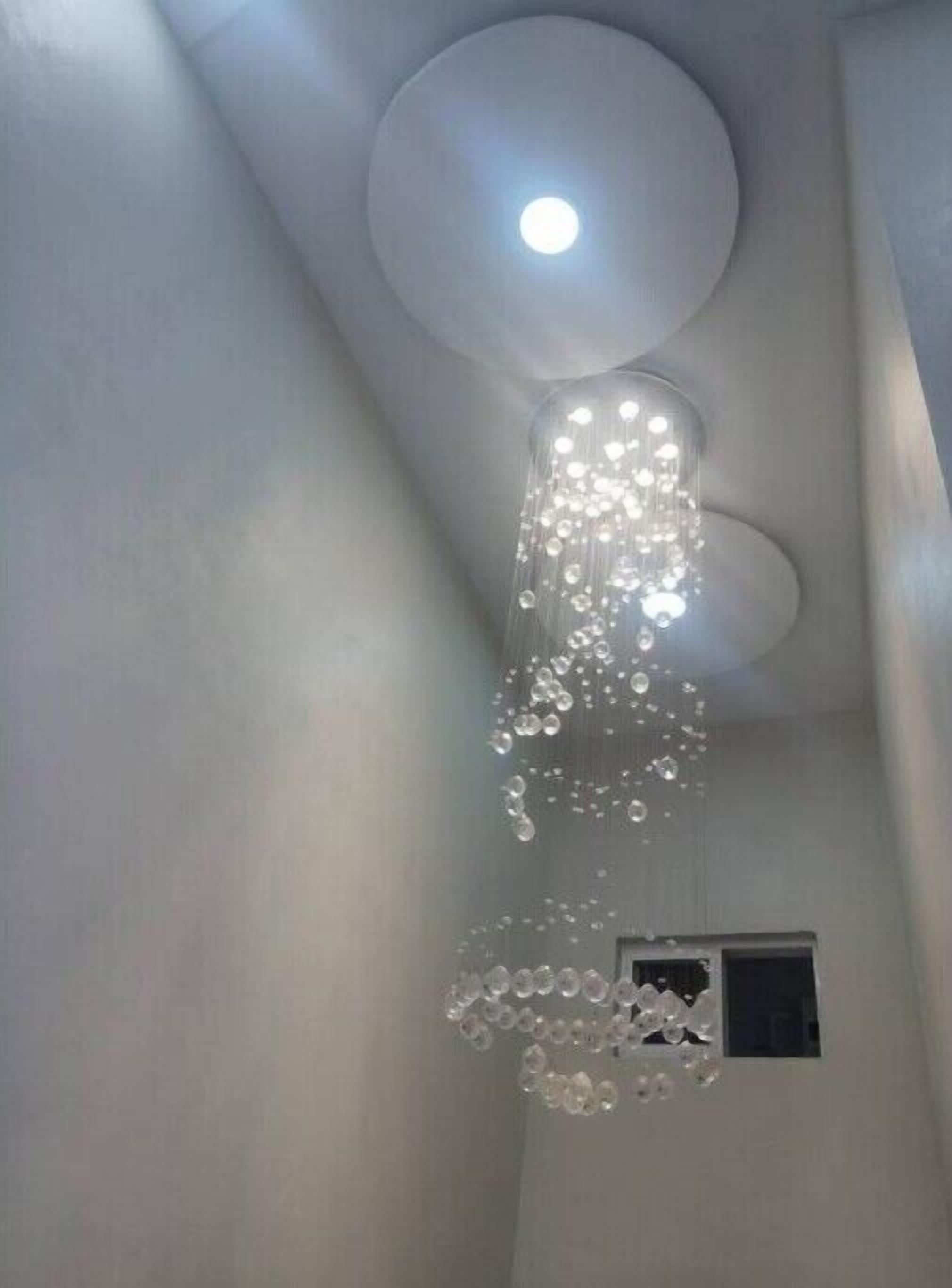 A ceiling with a central light fixture and a decorative element hanging below it.
