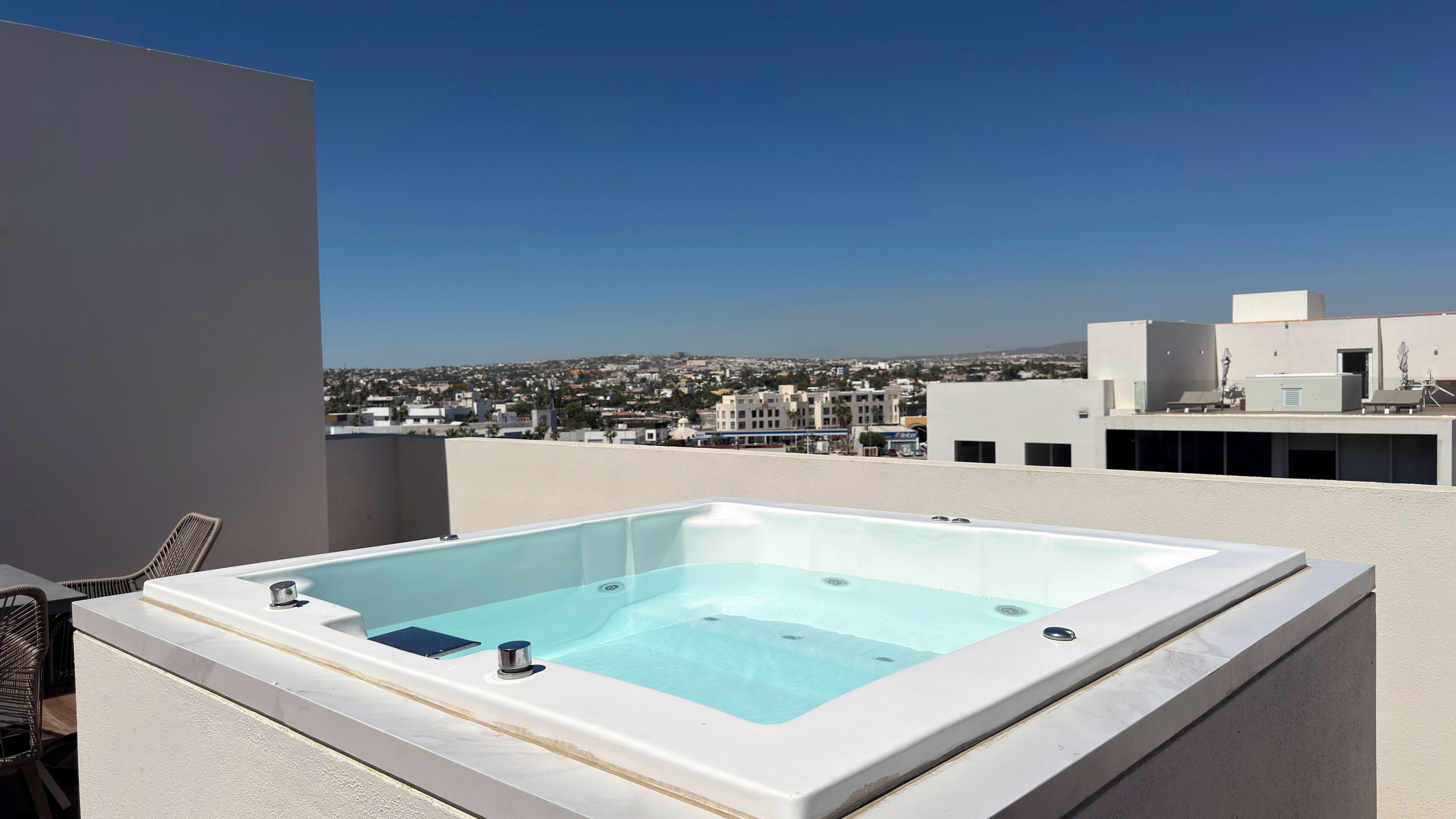 A rooftop pool with a clear view of the cityscape in the background.