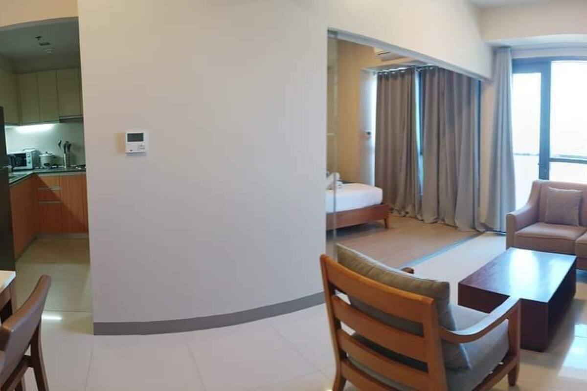 A compact living space with a kitchenette, a dining area, a sofa, and a bed.