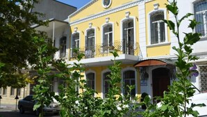 A yellow building with a balcony and a door. - Swan Hotel Baku  (Baku)
