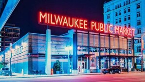 Un bâtiment illuminé la nuit par une enseigne au néon sur laquelle on peut lire « Milwaukee Public Market ».