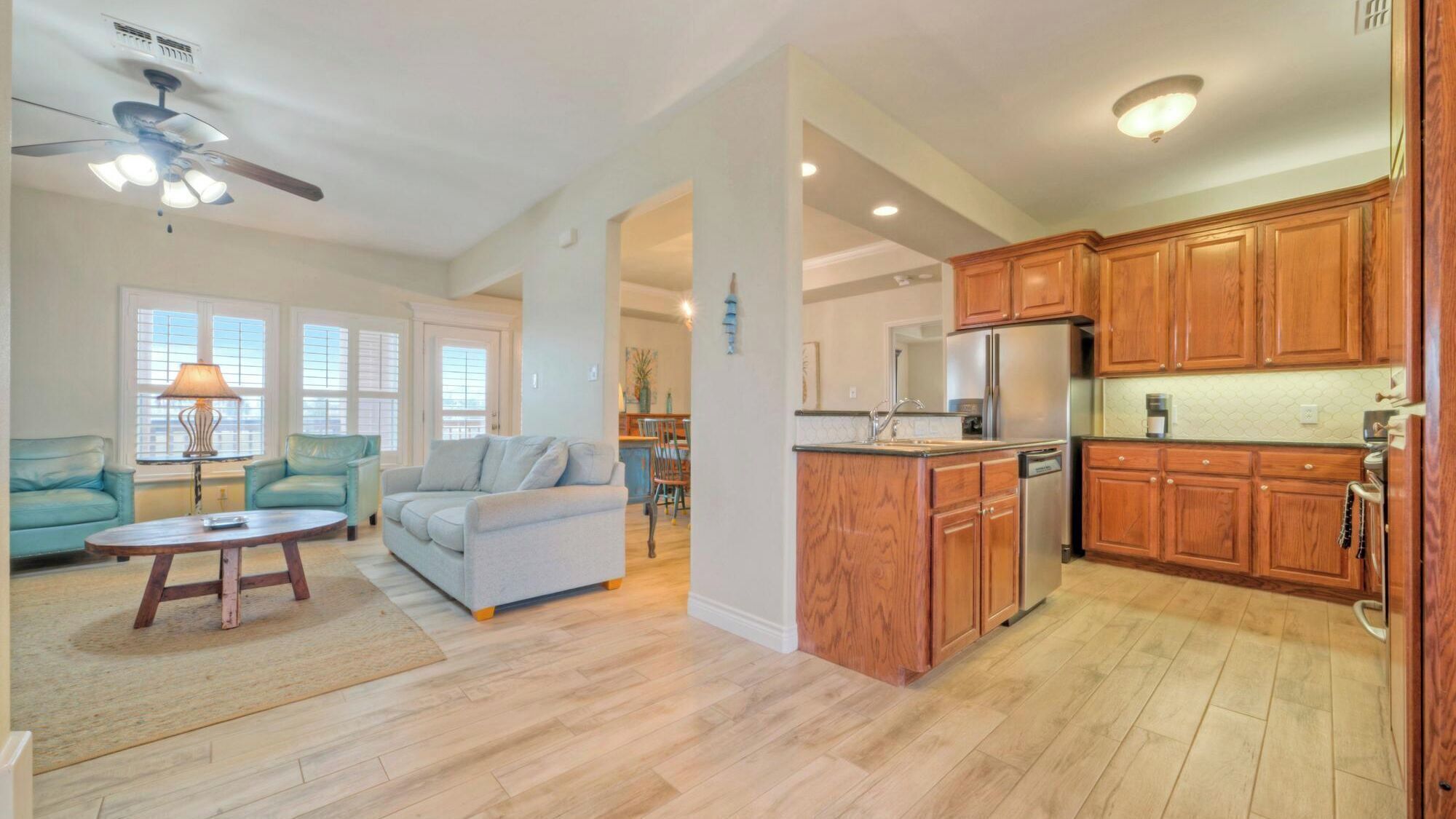 A spacious living area with a sofa, a coffee table, and a ceiling fan.