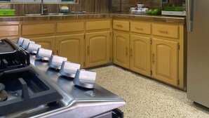 A kitchen with wooden cabinets, a stainless steel refrigerator, and a microwave. - Lachemar Guest House (Ocho Rios)