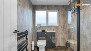 Un bagno moderno con servizi igienici, lavabo e zona doccia.