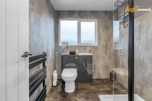 A modern bathroom with a toilet, sink, and shower area. - West Lothian 5 Beds + car space (Whitburn)