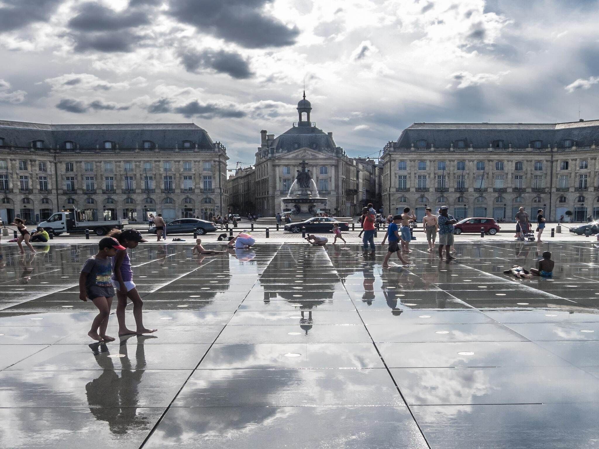Una amplia plaza con una fuente central, rodeada de edificios históricos.