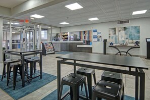 A reception area with a counter, stools, and a large number '6' sign. - Studio 6 Mesquite, Tx – Town East (Mesquite)