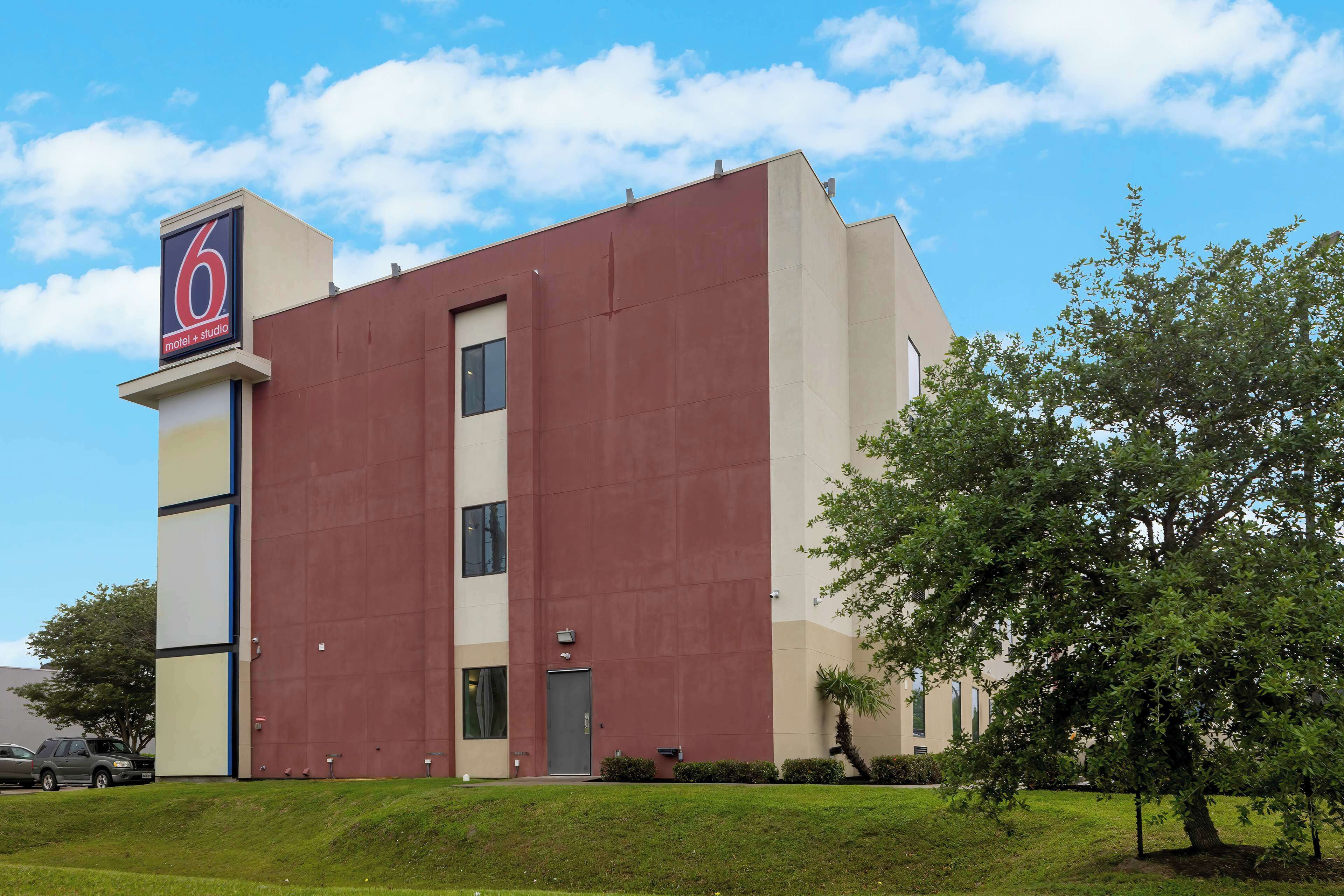 A modern building with a prominent '6' sign, likely a motel or hotel, with a flat roof and a large entrance door.