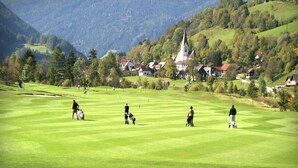 Golfkenttä, jonka taustalla näkyy kirkko ja taloja.