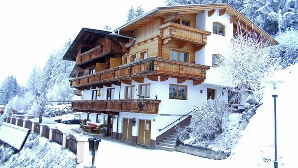 A multi-story wooden chalet with balconies, set in a snowy mountainous area. - Apartment in Gerlosberg near Ski Lift (Zell am Ziller-Gerlosberg)