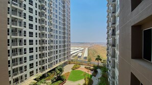 A high-rise residential building with multiple balconies and a landscaped courtyard. - Cozy And Restful Studio Tokyo Riverside Pik 2 Apartment (Teluknaga)