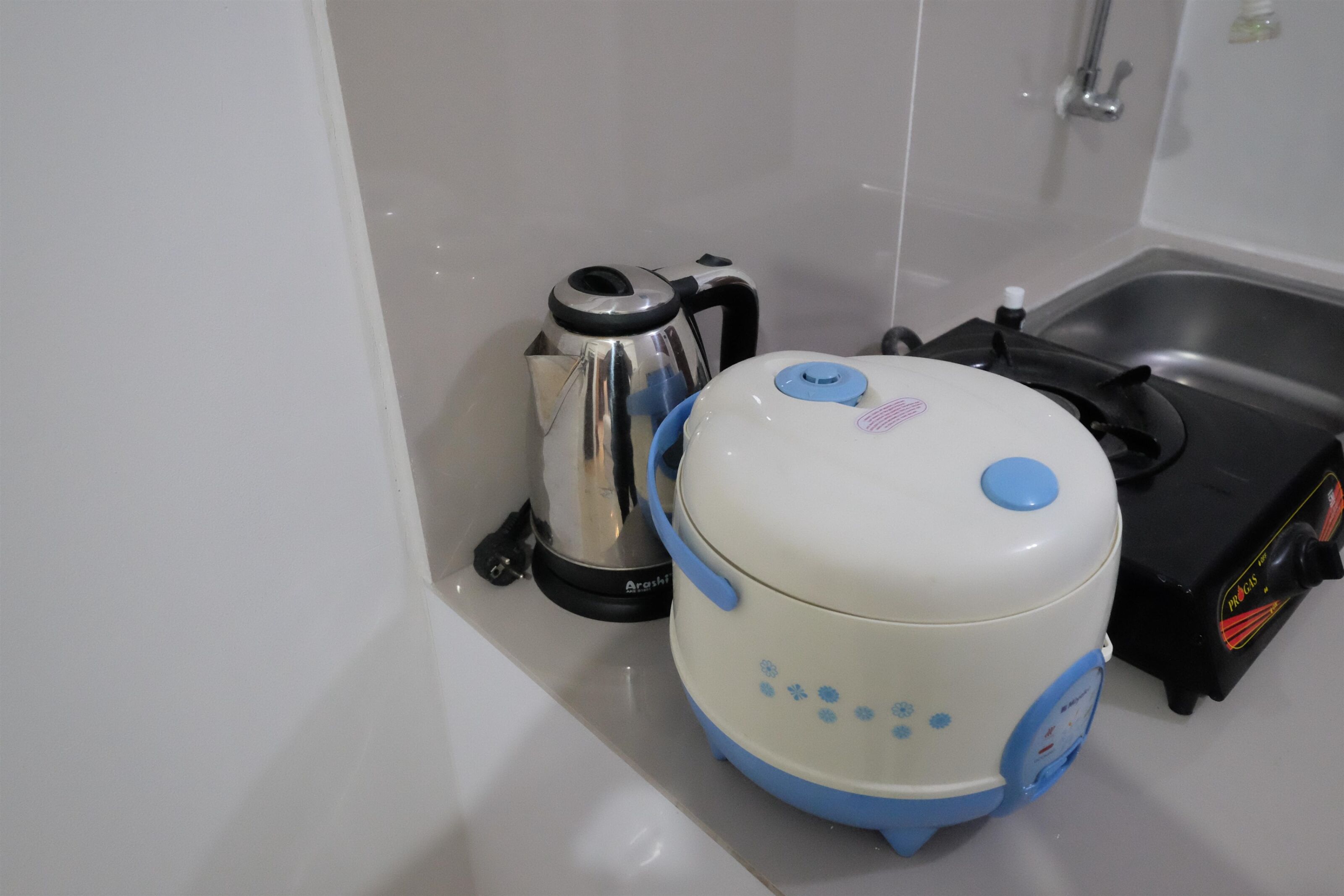 A kitchen with a kettle, a rice cooker, and a toaster.