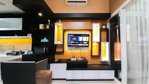 A modern kitchen with a built-in TV, a microwave, and a coffee machine. - Comfortable And Homey 1Br At Uttara The Icon Apartment (Depok)