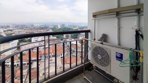A balcony with a view of a cityscape, a York air conditioning unit, and a metal railing. - Best Location 1Br Without Living Room Apartment Braga City Walk (Bandung)