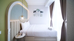 Ein ordentlich eingerichtetes Hotelzimmer mit einem Bett, einem kleinen Tisch mit einer Zeitschrift und Wandbildern.