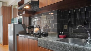 Une cuisine moderne équipée d’un réfrigérateur en acier inoxydable, d’une cuisinière à gaz et d’un plan de travail en granit.