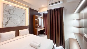 A hotel room with a large bed, a marble-framed artwork, a vanity with a mirror, and a dark curtain. - Spacious 2Br At Delft Ciputra Makassar Apartment (Makassar)