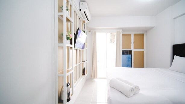 Een hotelkamer met een bed, een kledingkast, een bureau en een kitchenette.