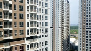 A high-rise residential building with multiple balconies and a view of a green landscape in the background. - Good Choice And Cozy Studio At Tokyo Riverside Pik 2 Apartment (Teluknaga)