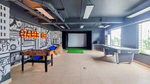 A modern indoor space with a foosball table, a pool table, and a projection screen. - Best Deal And Homey Studio Sky House Alam Sutera Apartment (Tangerang)