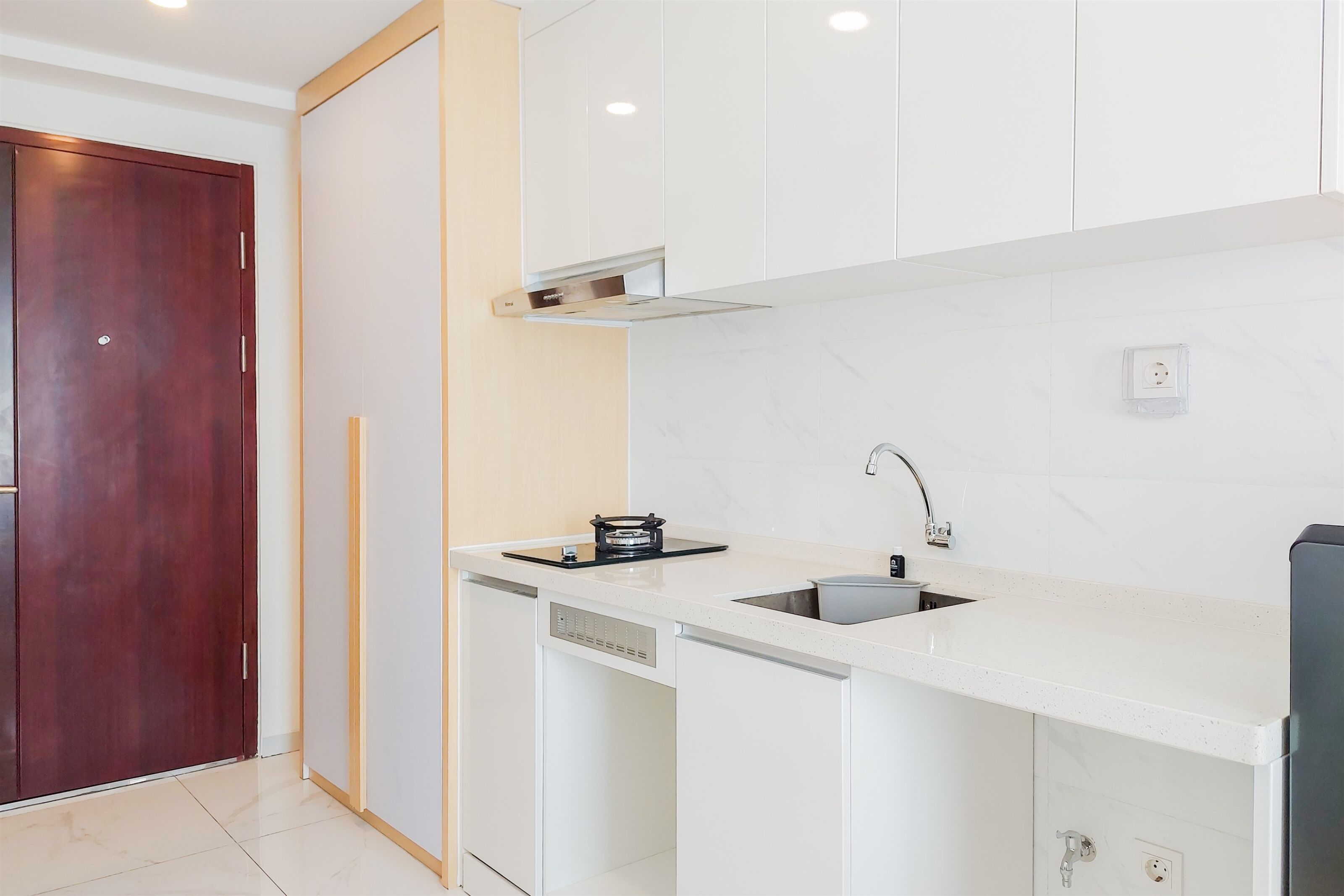 A modern kitchen with white cabinets, a built-in dishwasher, a stove, and a sink.