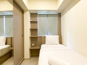 Cozy retreat with a single bed, wardrobe, and ample storage.