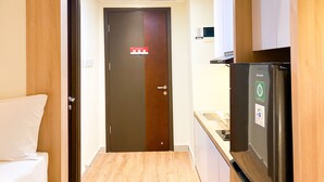 Eine kleine Küche mit Kühlschrank, Mikrowelle und Spüle.