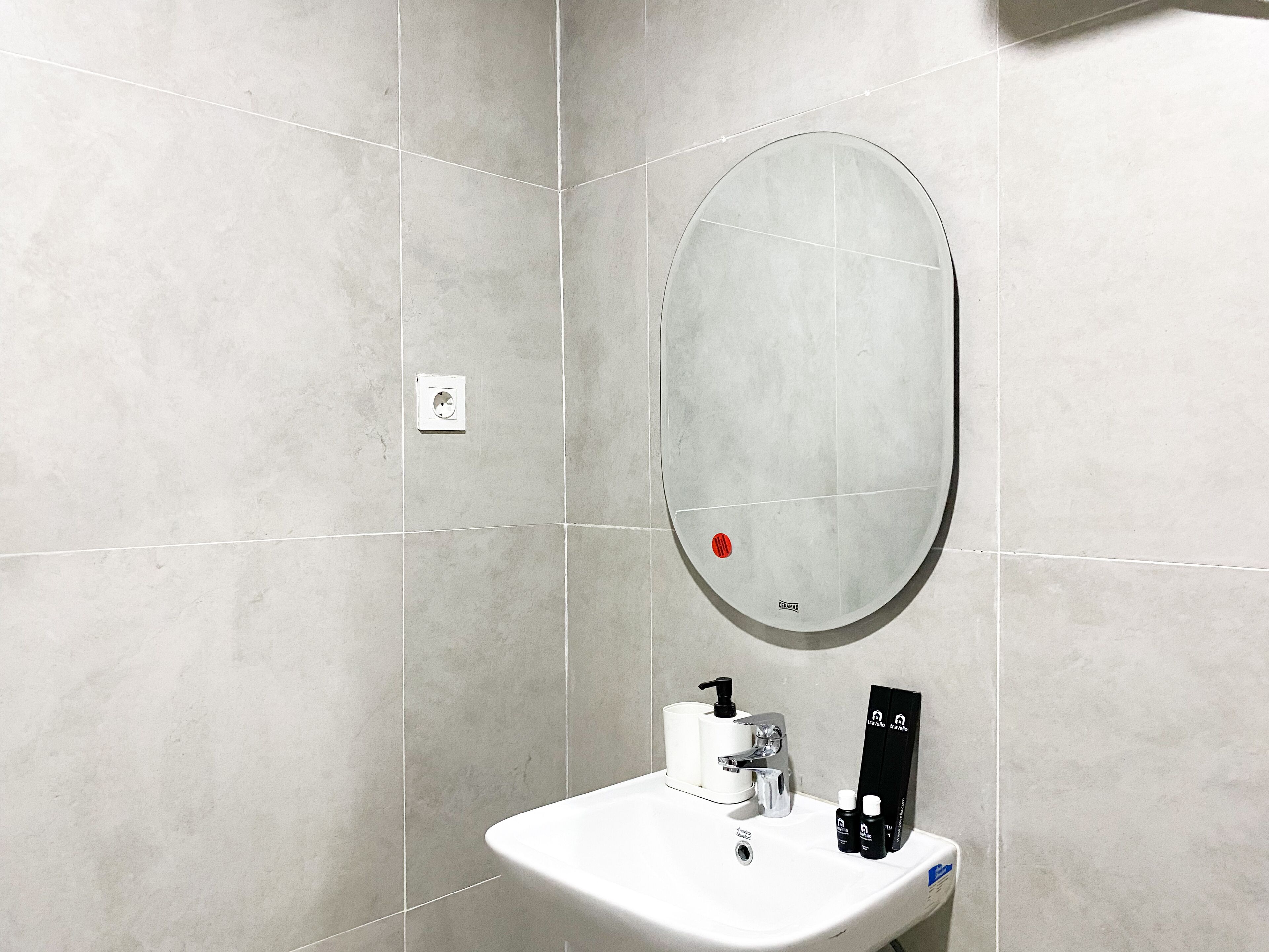 A bathroom with a white sink, a mirror, and a hand dryer.