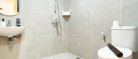 Un baño con inodoro, lavamanos y ducha.