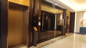 A modern elevator with a sleek design, a control panel, and a glass door.