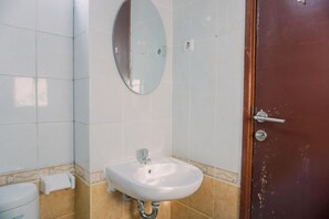 A bathroom with a white sink, a mirror, and a door. - Comfortable And Modern 2Br At Grand Palace Kemayoran Apartment (Jakarta)