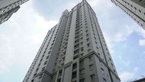 A tall, modern high-rise building with multiple balconies and windows. - Comfortable And Modern 2Br At Grand Palace Kemayoran Apartment (Jakarta)