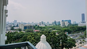 A cityscape with a prominent white dome structure in the foreground, surrounded by dense greenery and various buildings in the background. - Wonderful And Homey 2Br At Grand Palace Kemayoran Apartment (Jakarta)