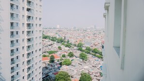 Un palazzo alto con numerosi balconi e vista su una zona urbana densamente popolata.