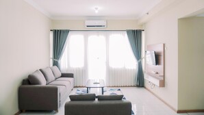 Un soggiorno moderno con un divano, un tavolino da caffè e una TV a parete.