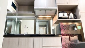Une cuisine moderne avec des meubles en bois, une hotte de cuisine en acier inoxydable et un appareil à café intégré.