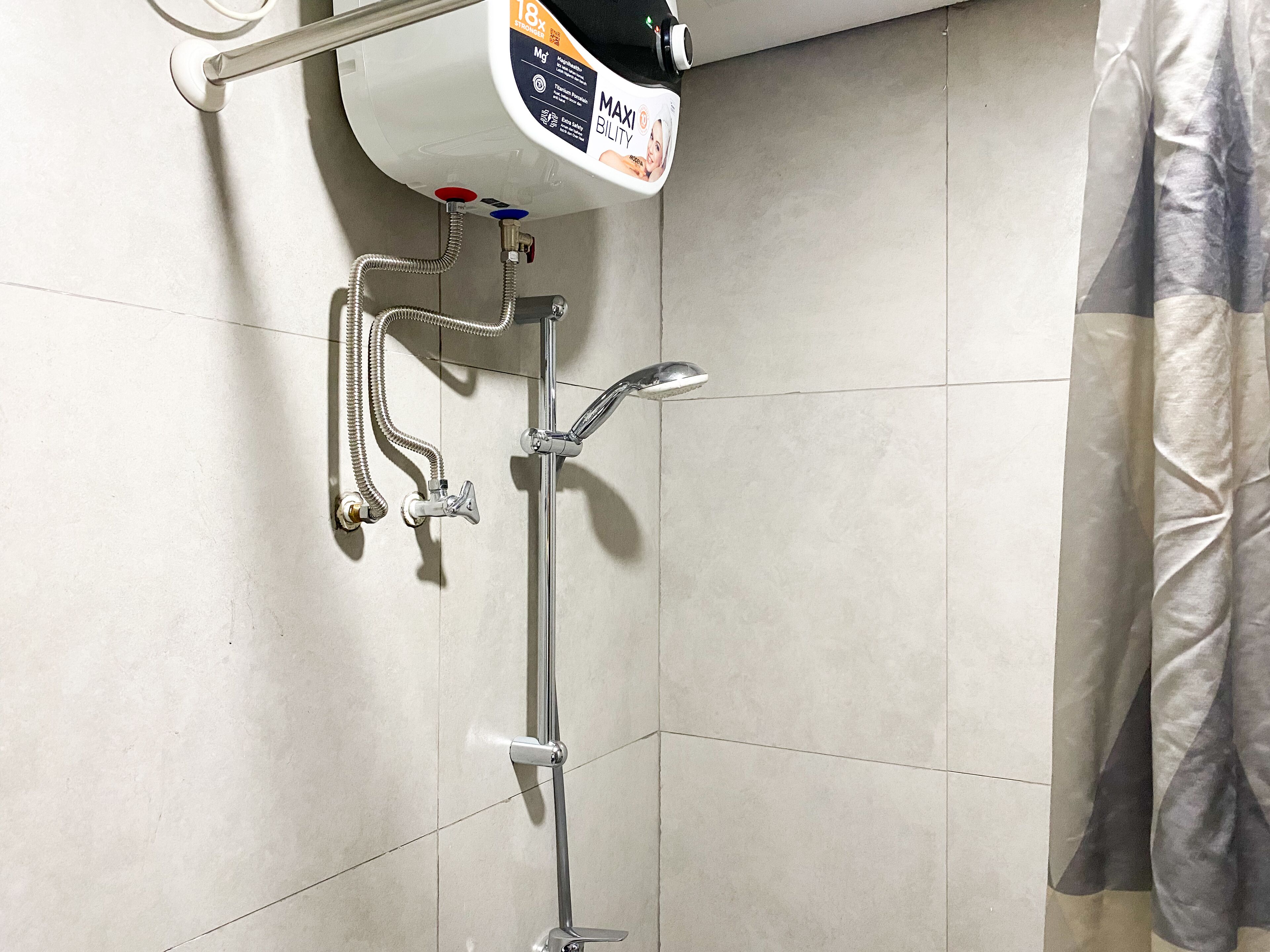 A shower with a handheld showerhead, a wall-mounted faucet, and a flexible hose.
