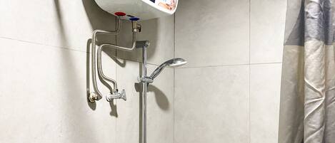 A shower with a handheld showerhead, a wall-mounted faucet, and a flexible hose.