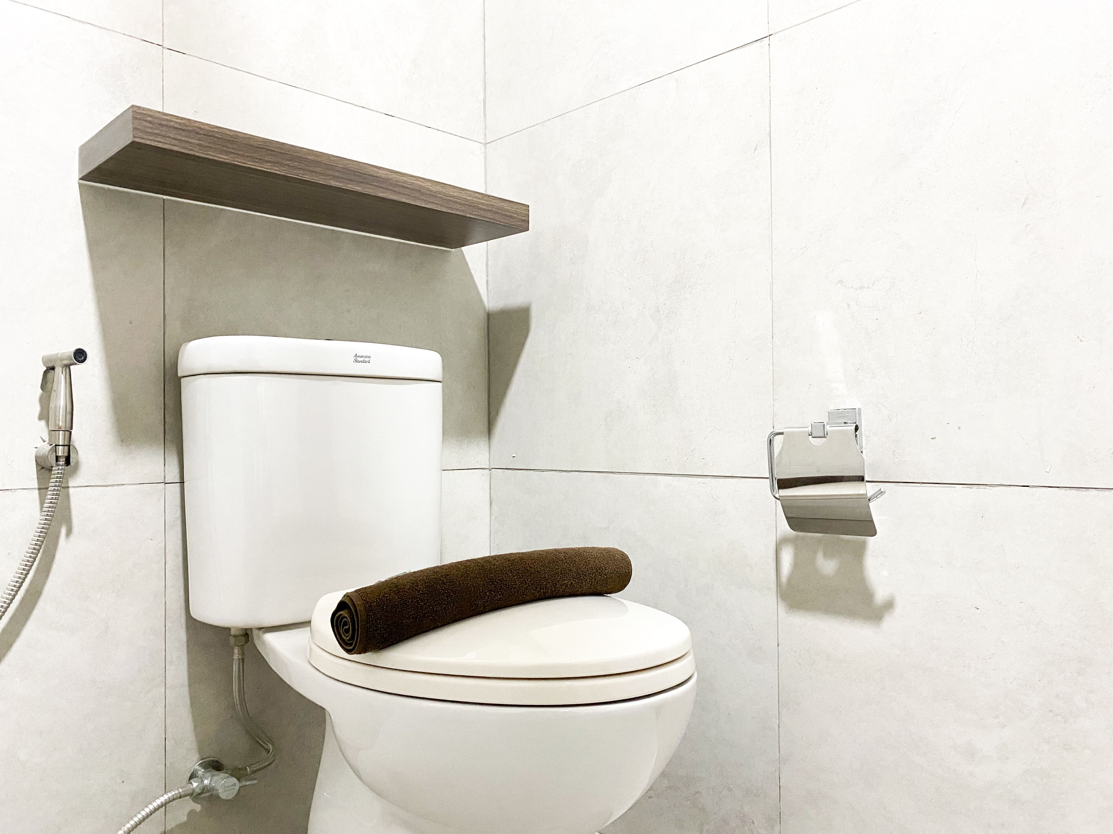 Ein modernes Badezimmer mit Toilette, Dusche und Handtuchhalter.