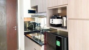 Une cuisine moderne équipée d’un four encastré, d’un four à micro-ondes, d’une machine à café et d’un lave-vaisselle.