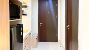 A compact kitchen with a microwave, sink, and cabinets.